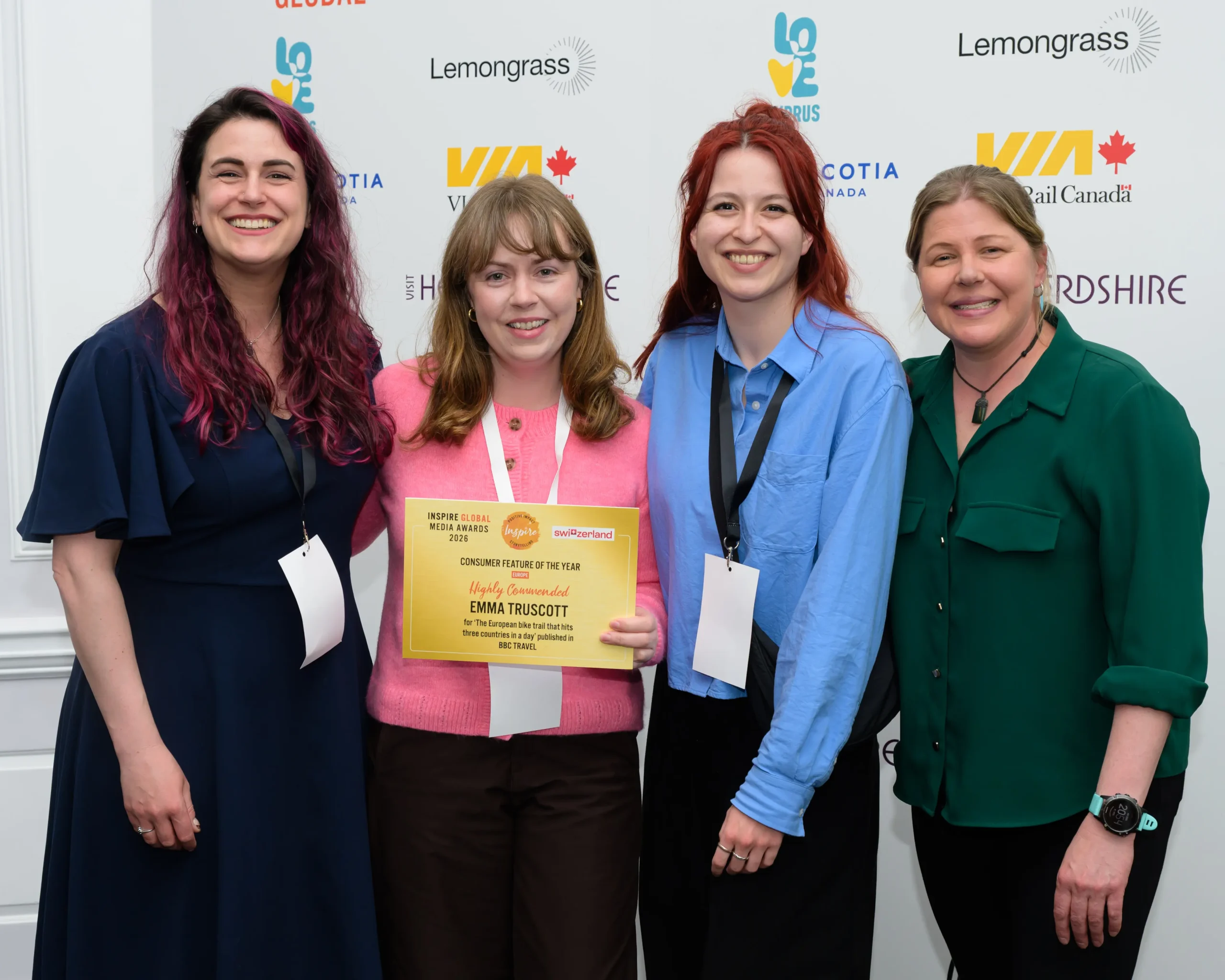 Freelance travel writer Emma Truscott holding an award certificate with three women at an event